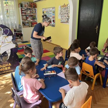 Деца седнали на маса и рисуват ракети в арт работилница към книгата Звездна одисея