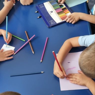 Деца рисуват ракети на синя маса като част от арт работилничката на Звездна одисея