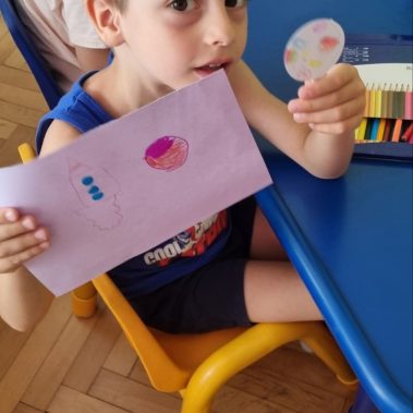 Дете показва своята рисунка на ракете и планета, които е направил на арт работилницата по книгата звездна одисея