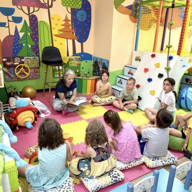 Авторката държи своята детската книга „Звездна одисея“ и се усмихва – авторът на вълшебна история за деца