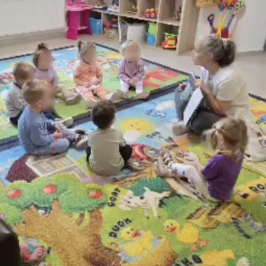 Галя Ненчева прави четене за деца пред деца от частна ясла седнали в кръг около нея